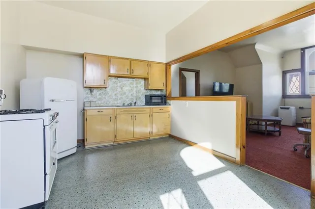 a large white kitchen with cabinets
