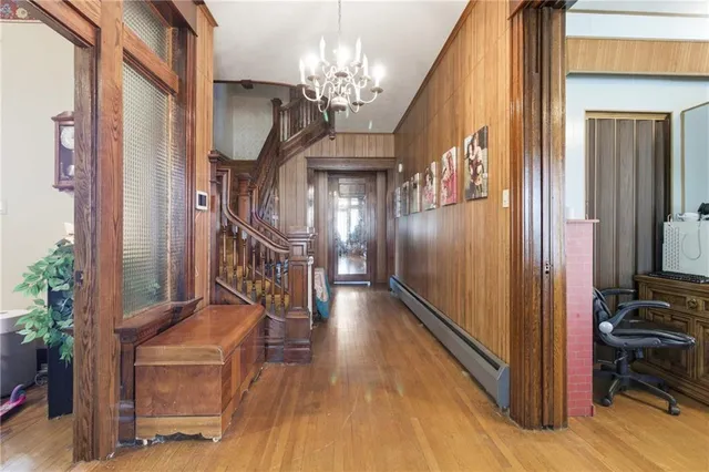 a view of a hallway with wooden floor and staircase
