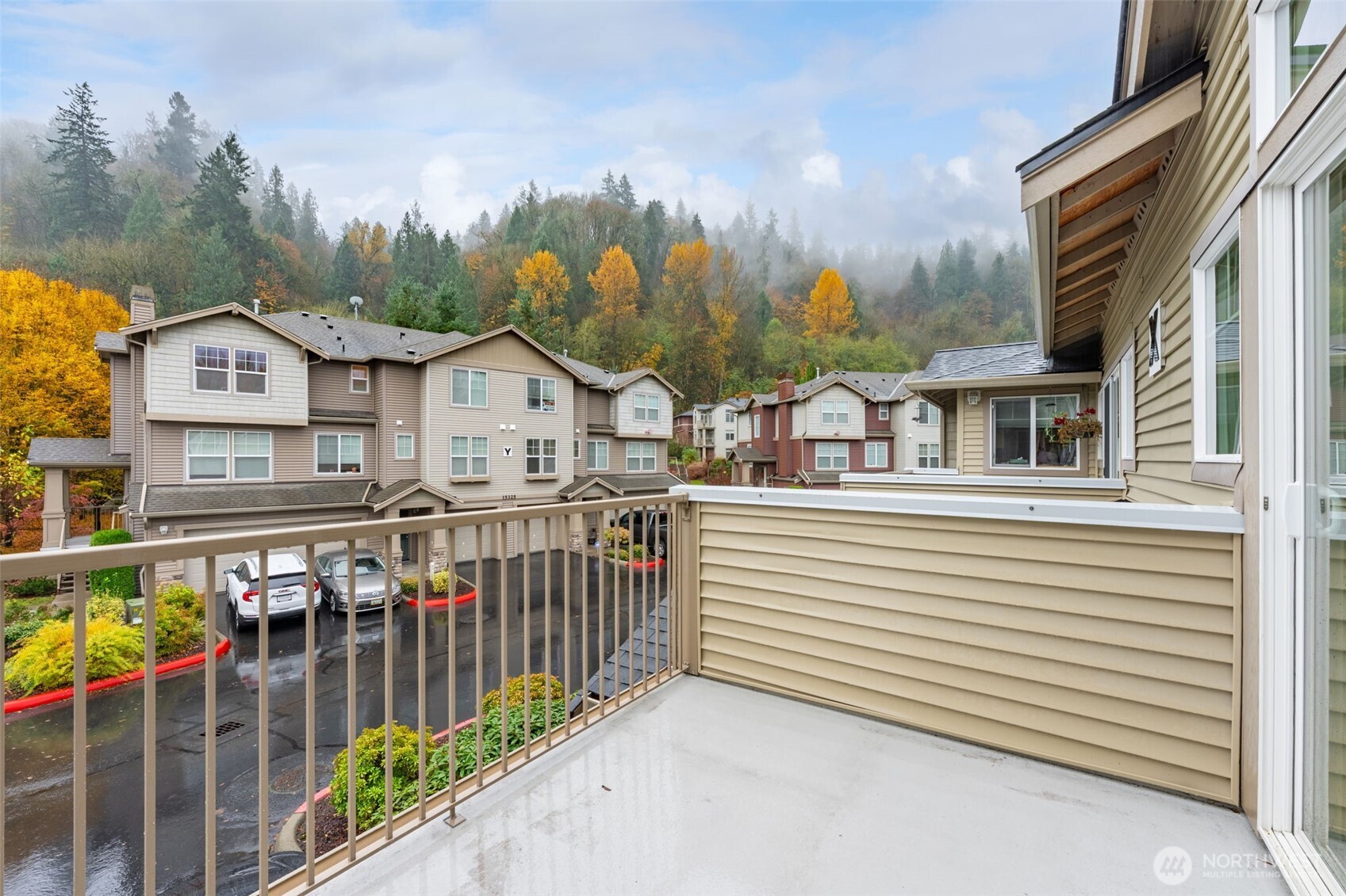 15325 Southeast 155th Place, Unit X4 Renton, WA 98058 - Photo 20 of 23 a view of a white house with large windows and a small yard