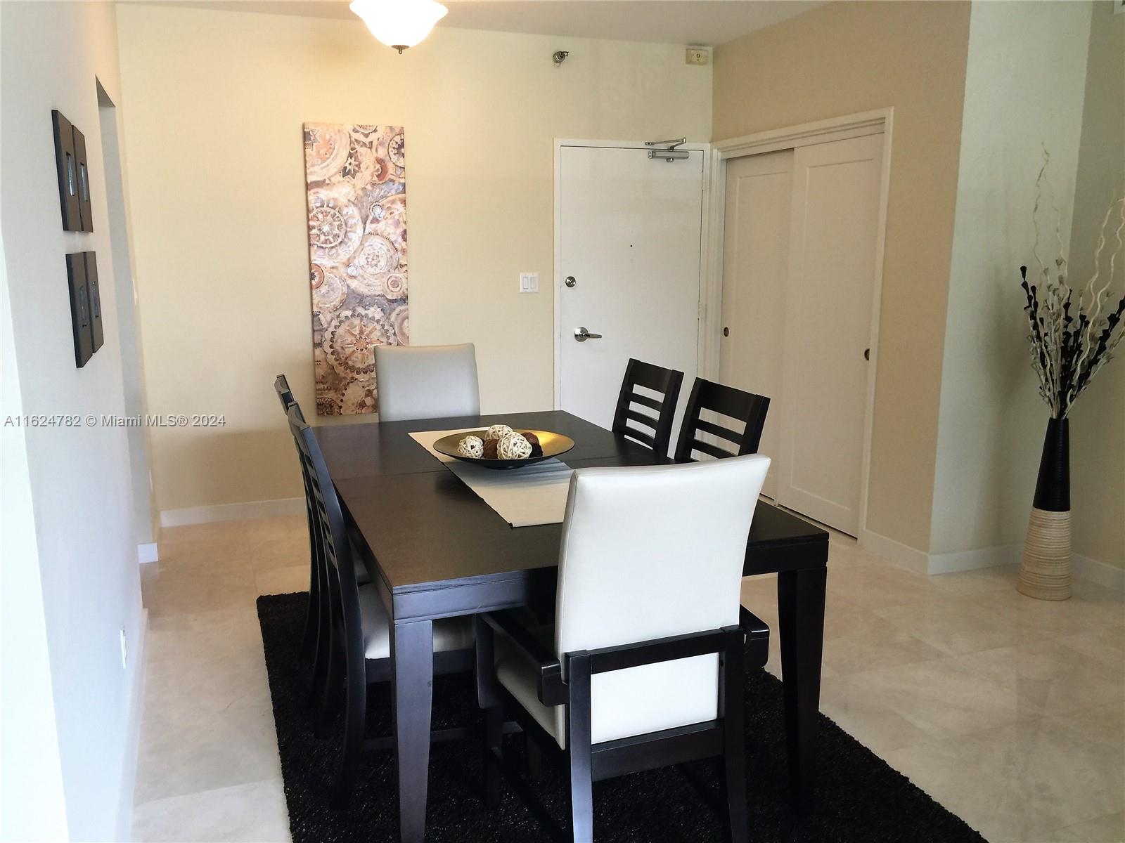 5161 Collins Avenue, Unit 207 Miami Beach, FL 33140 - Photo 2 of 7 a view of a dining room that has a table and a chair