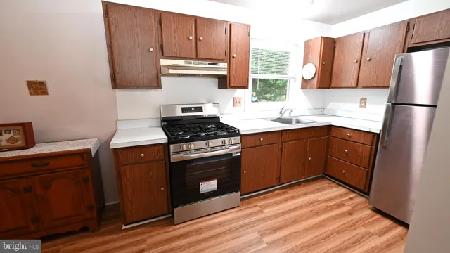 a kitchen with stainless steel appliances granite countertop a stove a sink dishwasher and a refrigerator