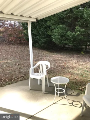 a blue chair sitting in a backyard of a house