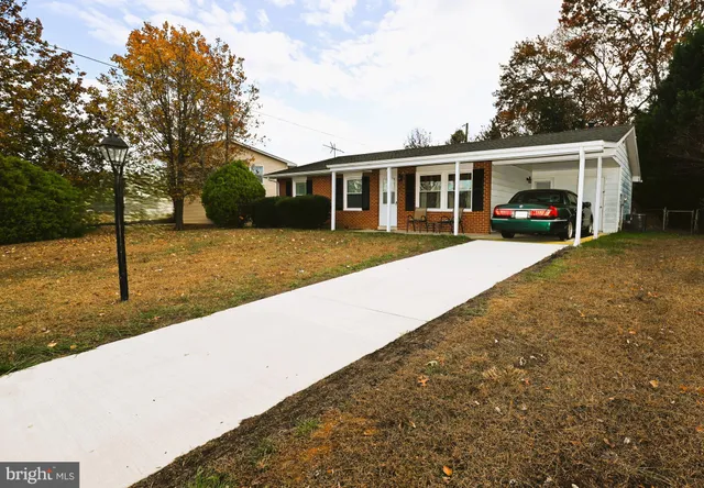 a view of house and yard with trees