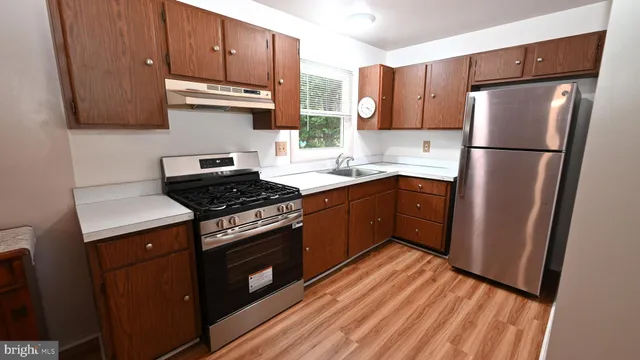 a kitchen with stainless steel appliances granite countertop a stove a refrigerator and a sink