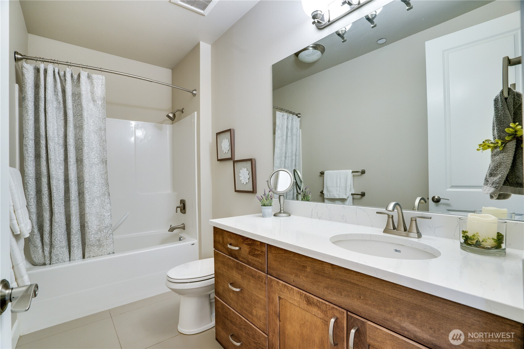 5105 Grand Loop, Unit 105 Tacoma, WA 98407 - Photo 32 of 39 a bathroom with a granite countertop sink toilet a large mirror a bathtub and shower