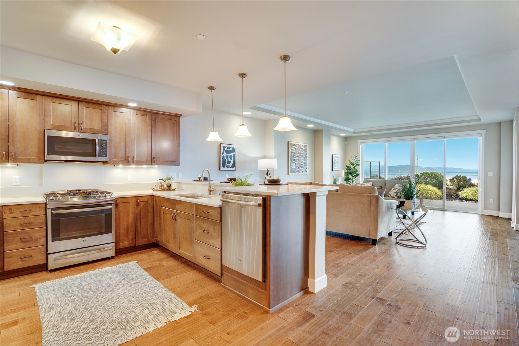 5105 Grand Loop, Unit 105 Tacoma, WA 98407 - Photo 6 of 39 a kitchen with kitchen island granite countertop wooden floors and stainless steel appliances