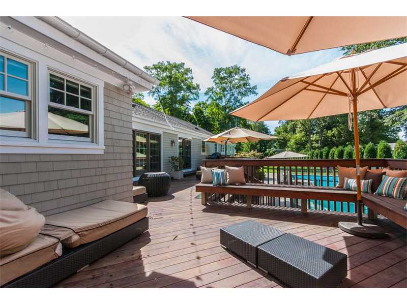Undisclosed Address Riverside, CT 06878 - Photo 24 of 25 a view of a roof deck with table and chairs under an umbrella with wooden floor
