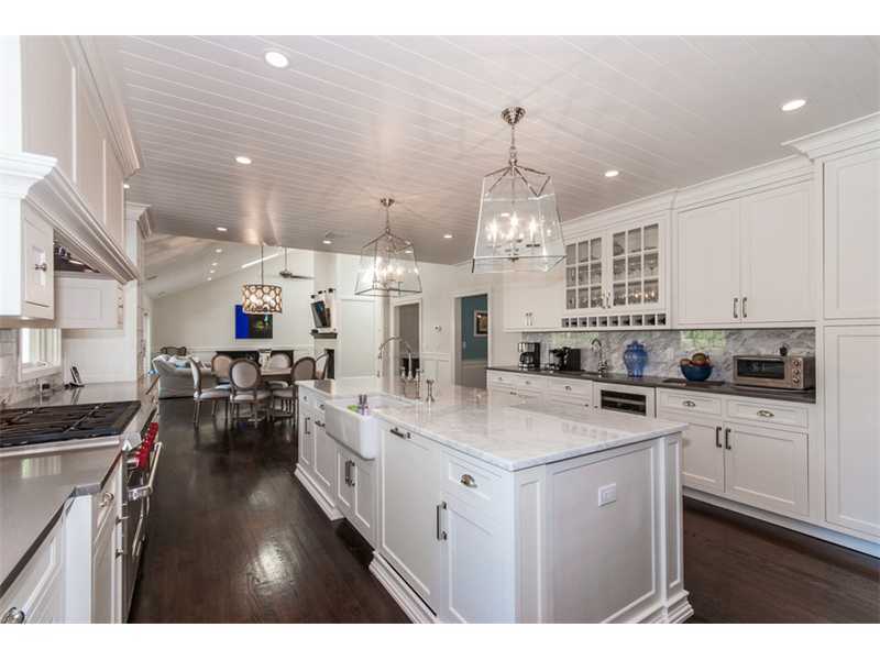 Undisclosed Address Riverside, CT 06878 - Photo 3 of 25 a kitchen with stainless steel appliances kitchen island granite countertop a sink dishwasher a stove a dining table and chairs with wooden floor