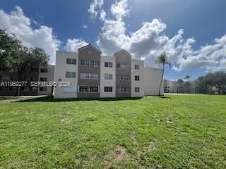 a view of a house with a big yard and large trees