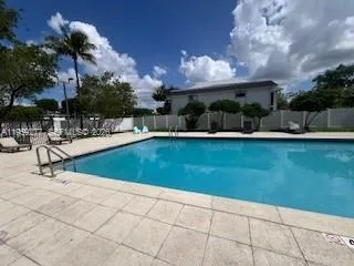 a view of a swimming pool with an outdoor seating and a kitchen