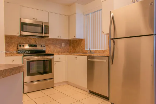 a kitchen with appliances a microwave and cabinets