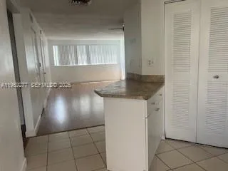 a view of a refrigerator in kitchen and cabinets