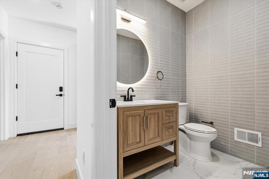150 Howland Avenue River Edge, NJ 07661 - Photo 38 of 45 a bathroom with a toilet sink and mirror
