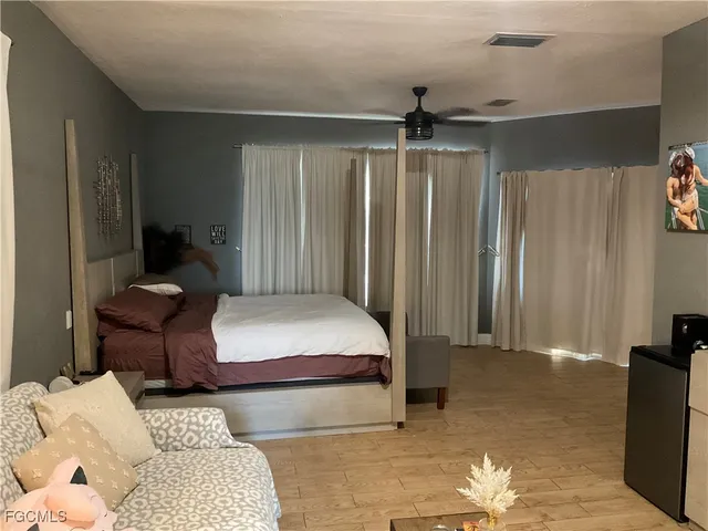 a bedroom with furniture and a large window