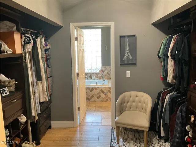 a view of walk in closet with clothes and shoes