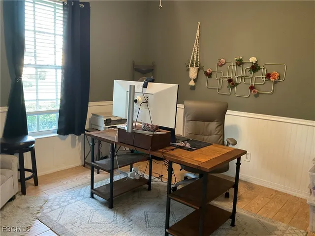 a view of a workspace with furniture and a window