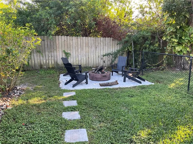 a backyard of a house with table and chairs