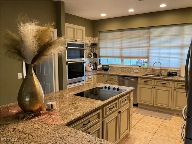 a kitchen with stainless steel appliances granite countertop a sink a stove and a microwave