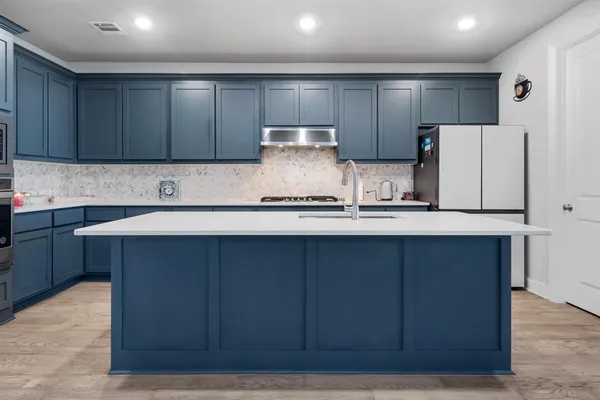 a kitchen with wooden cabinets and refrigerator