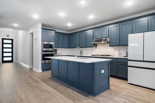 a kitchen with kitchen island granite countertop wooden cabinets and white appliances