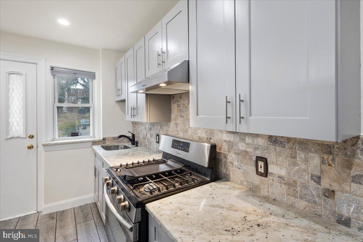 4027 D Street Southeast Washington, DC 20019 - Photo 11 of 32 a kitchen with stainless steel appliances granite countertop a stove a sink and a microwave