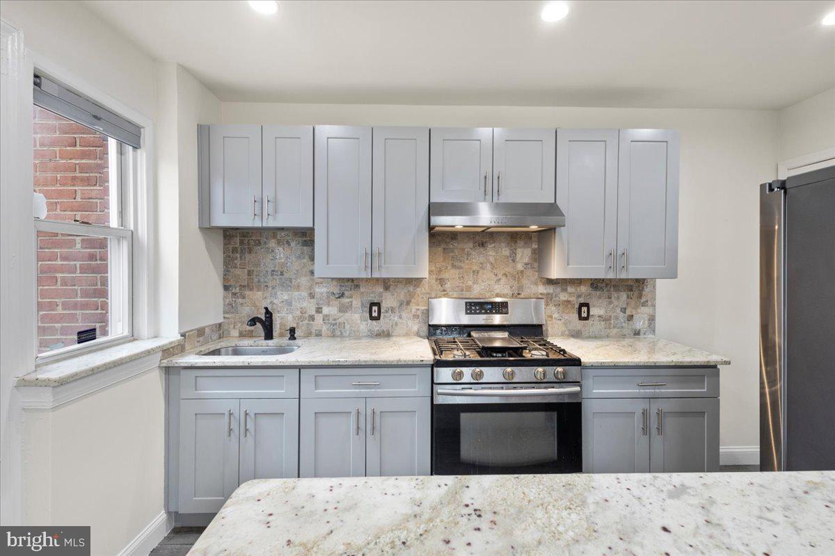 4027 D Street Southeast Washington, DC 20019 - Photo 12 of 32 a kitchen with a sink stove top oven and cabinets