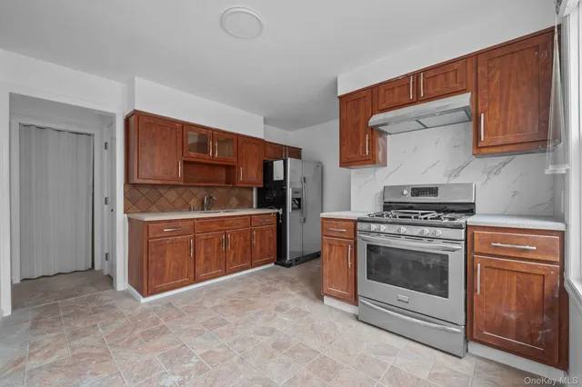 a kitchen with stainless steel appliances granite countertop a stove a sink and a refrigerator