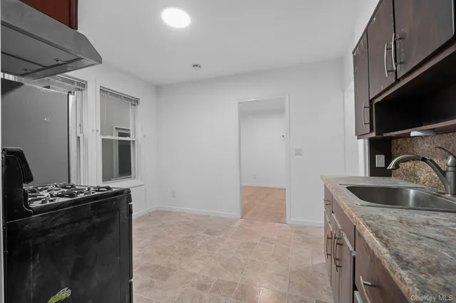 a kitchen with granite countertop a sink stove and refrigerator