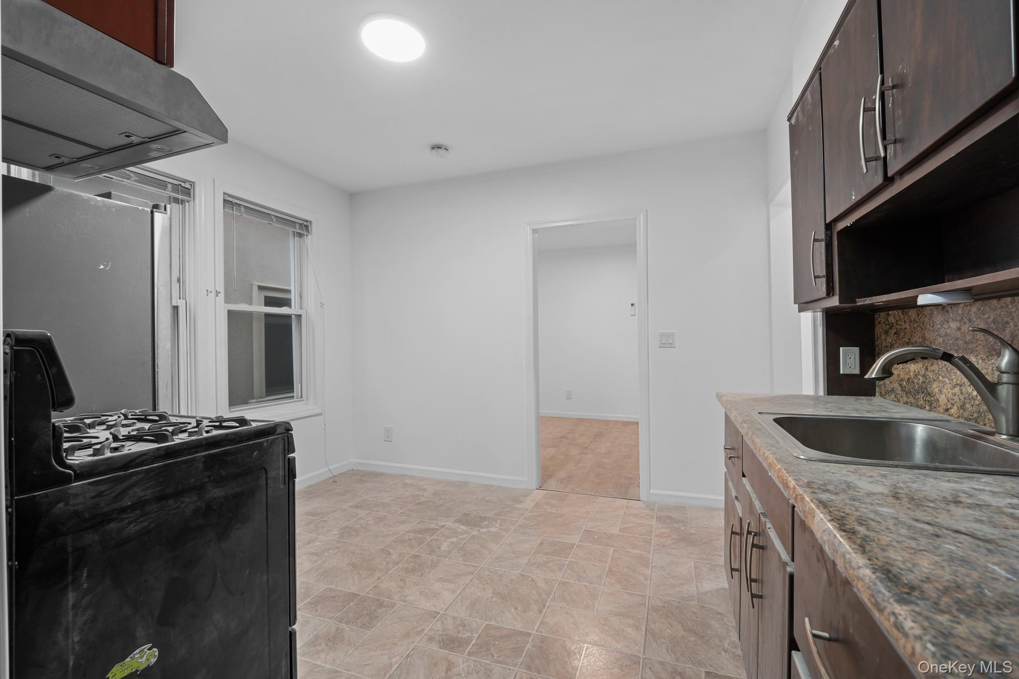 58-44 Fresh Pond Road Queens, NY 11378 - Photo 16 of 30 a kitchen with granite countertop a sink stove and refrigerator