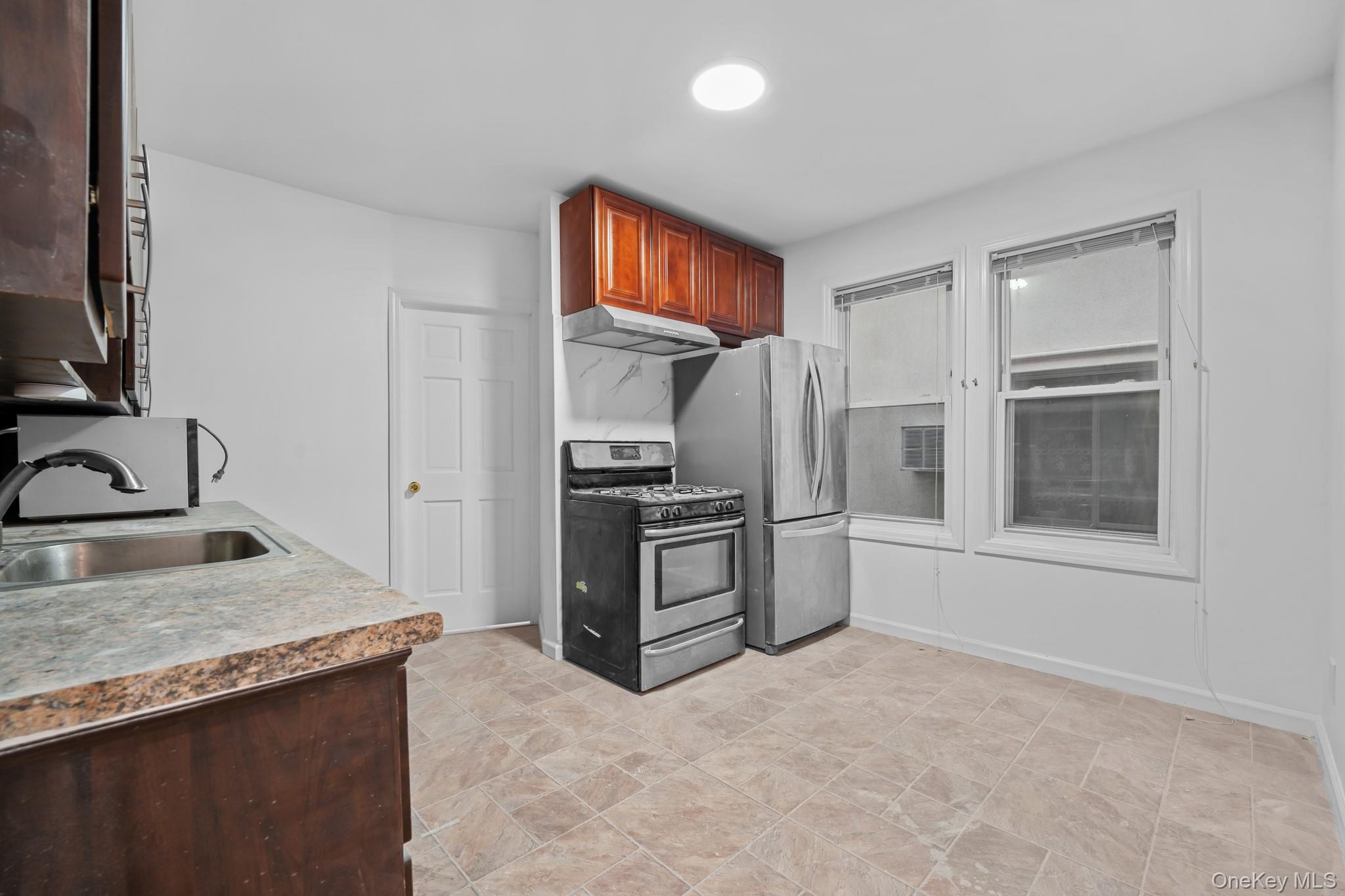 58-44 Fresh Pond Road Queens, NY 11378 - Photo 7 of 30 a kitchen with stainless steel appliances granite countertop a refrigerator stove and sink