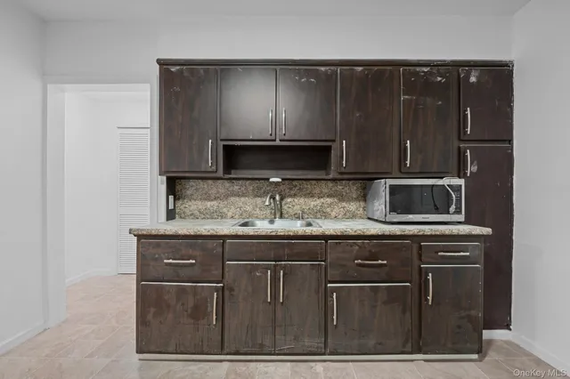 a kitchen with granite countertop a sink and a microwave oven