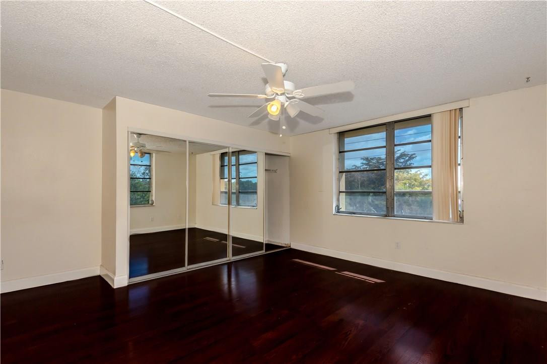 3285 Foxcroft Road, Unit E317 Miramar, FL 33025 - Photo 16 of 28 a view of a livingroom with wooden floor and a ceiling fan