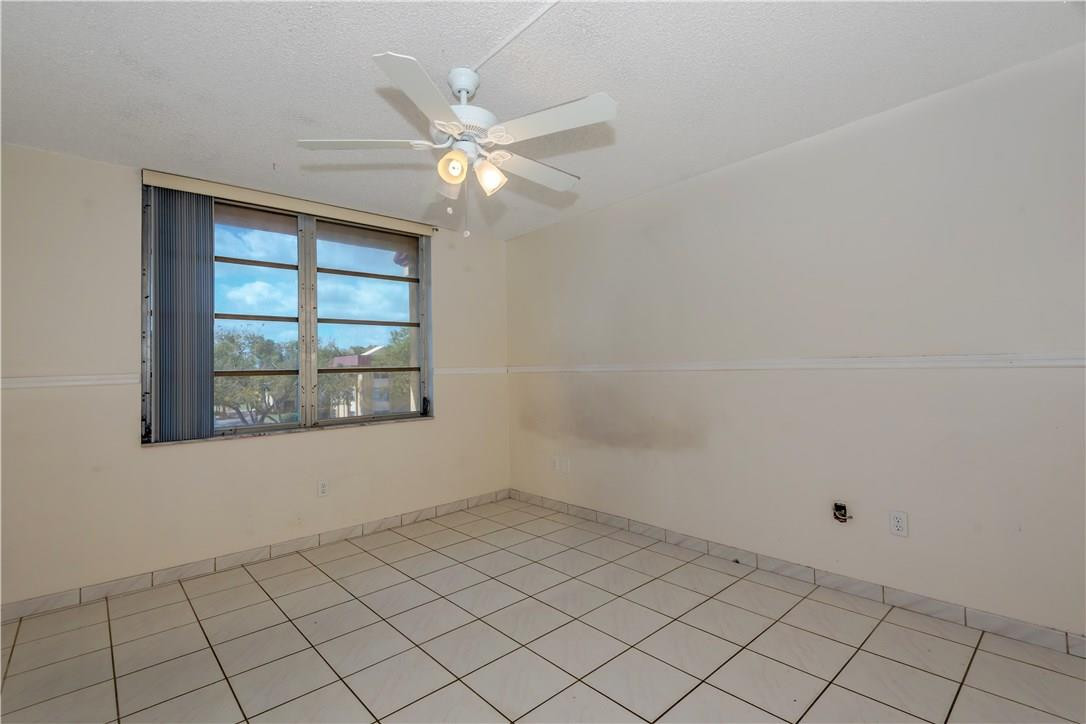 3285 Foxcroft Road, Unit E317 Miramar, FL 33025 - Photo 19 of 28 an empty room with windows and fan