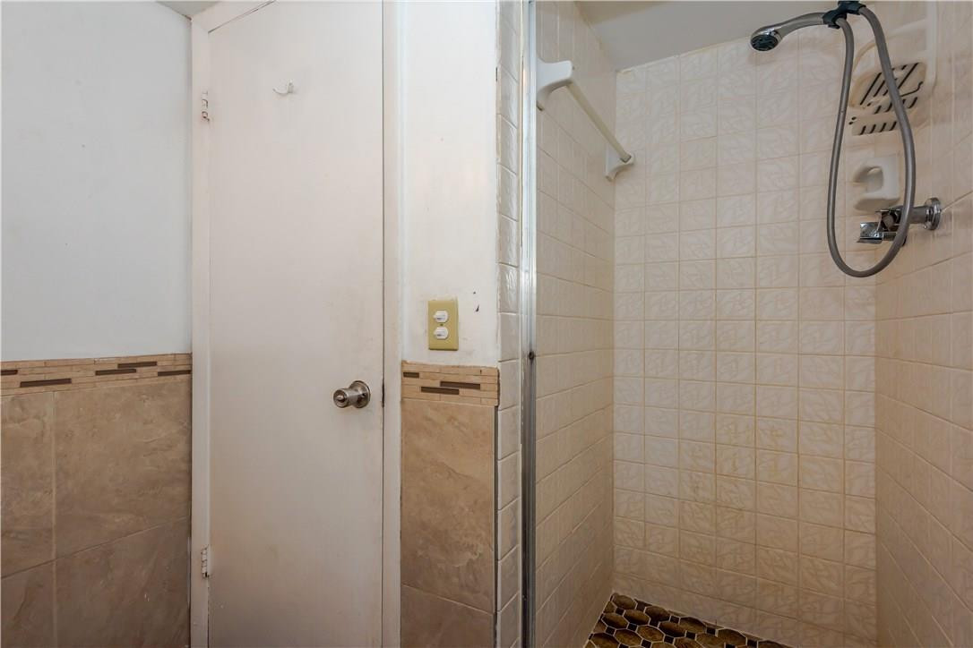 3285 Foxcroft Road, Unit E317 Miramar, FL 33025 - Photo 25 of 28 a bathroom with a glass shower door