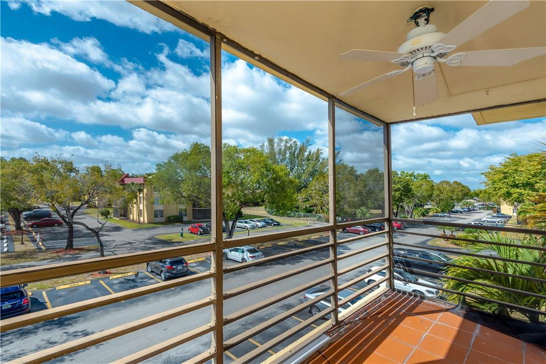 3285 Foxcroft Road, Unit E317 Miramar, FL 33025 - Photo 27 of 28 a view of a balcony with couches and wooden floor