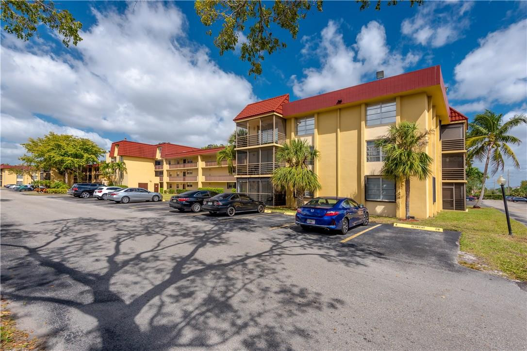 3285 Foxcroft Road, Unit E317 Miramar, FL 33025 - Photo 28 of 28 a view of a parked cars in front of a house