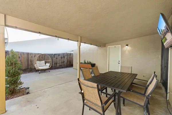 a backyard of a house with a table and chairs