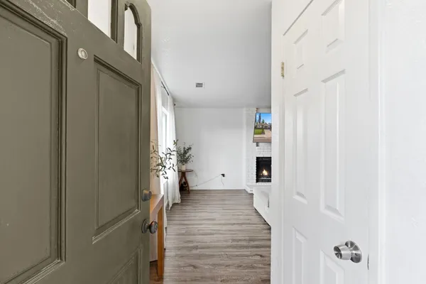 a view of a hallway with wooden floor and staircase