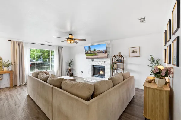 a living room with furniture a fireplace and a large window