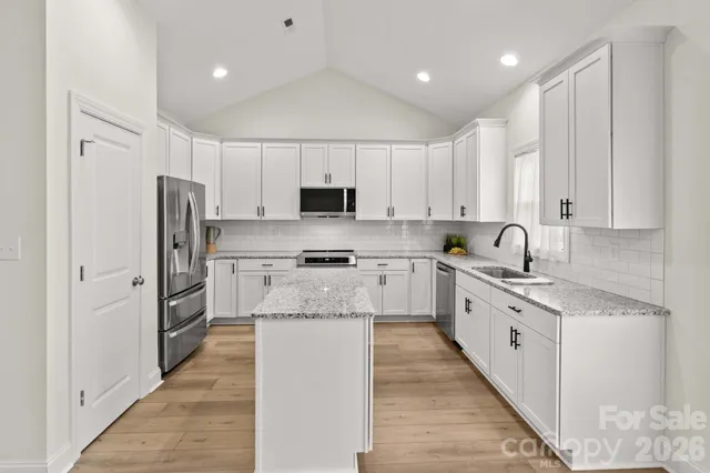 a large kitchen with stainless steel appliances granite countertop a stove a sink and a refrigerator