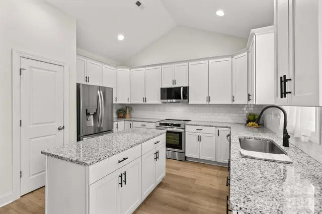 a kitchen with stainless steel appliances granite countertop a sink stove and refrigerator