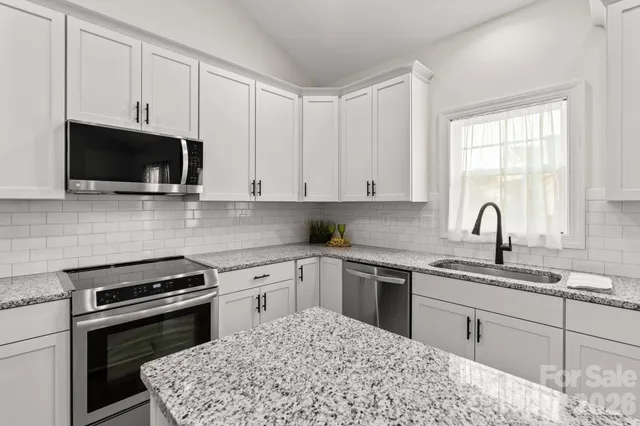 a kitchen with cabinets appliances and a sink