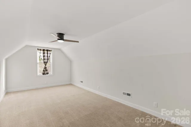 an empty room with windows and cabinet