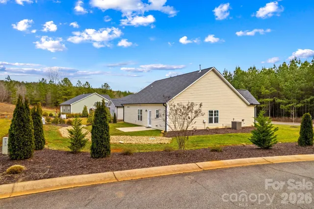 a view of a big house with a yard and plants