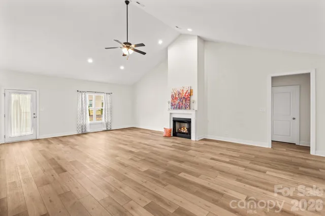 a view of empty room with wooden floor and ceiling fan