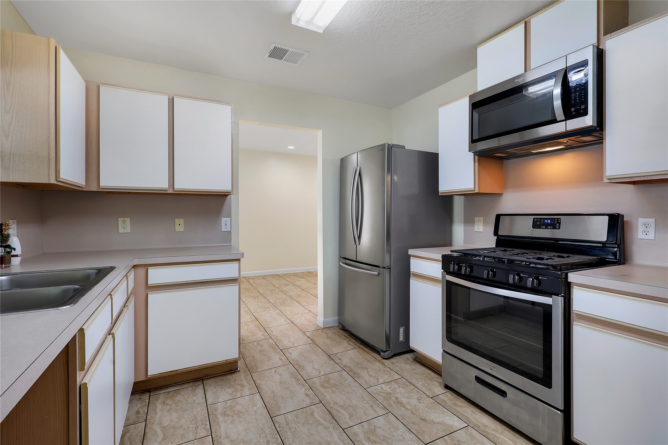 1117 Willersley Lane Channelview, TX 77530 - Photo 19 of 27 a kitchen with stainless steel appliances granite countertop a stove microwave and refrigerator