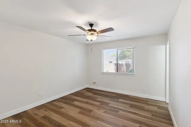 a view of a room with wooden floor and ceiling fan