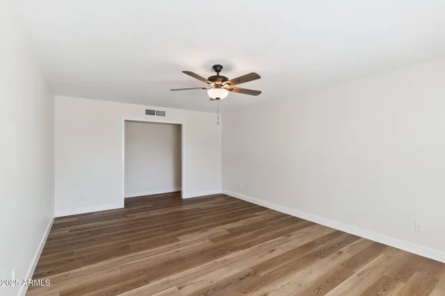 a view of an empty room with wooden floor