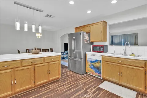 a kitchen with a sink wooden floor and stainless steel appliances