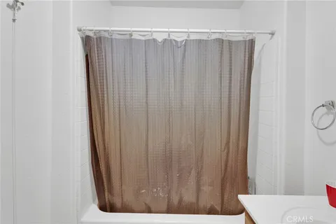 a bathroom with a shower curtain and a window